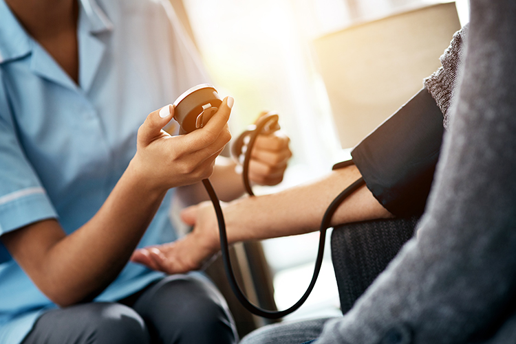 Nurse taking blood pressure reading.